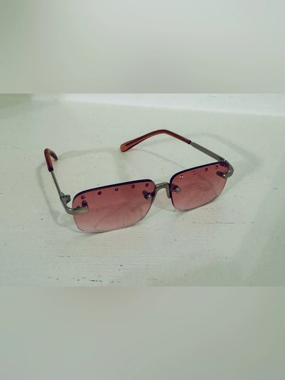 Stylish pink rimless sunglasses adorned with decorative rhinestones. These glass